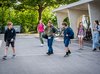 Degli studenti si spostano dalla rastrelliera delle biciclette alla scuola