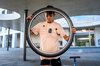 Un alunno tiene in mano la ruota di una bicicletta, presumibilmente per ripararla.