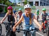 Un gruppo di studenti pedala nella stessa direzione. Una ragazza bionda è davanti a tutti, al centro.