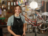 Una ragazza che ha imparato a riparare le biciclette sorridente in un’officina
